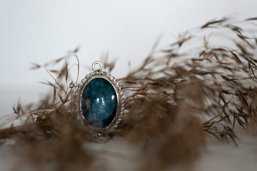 Oval teal stone pendant in ornate silver setting